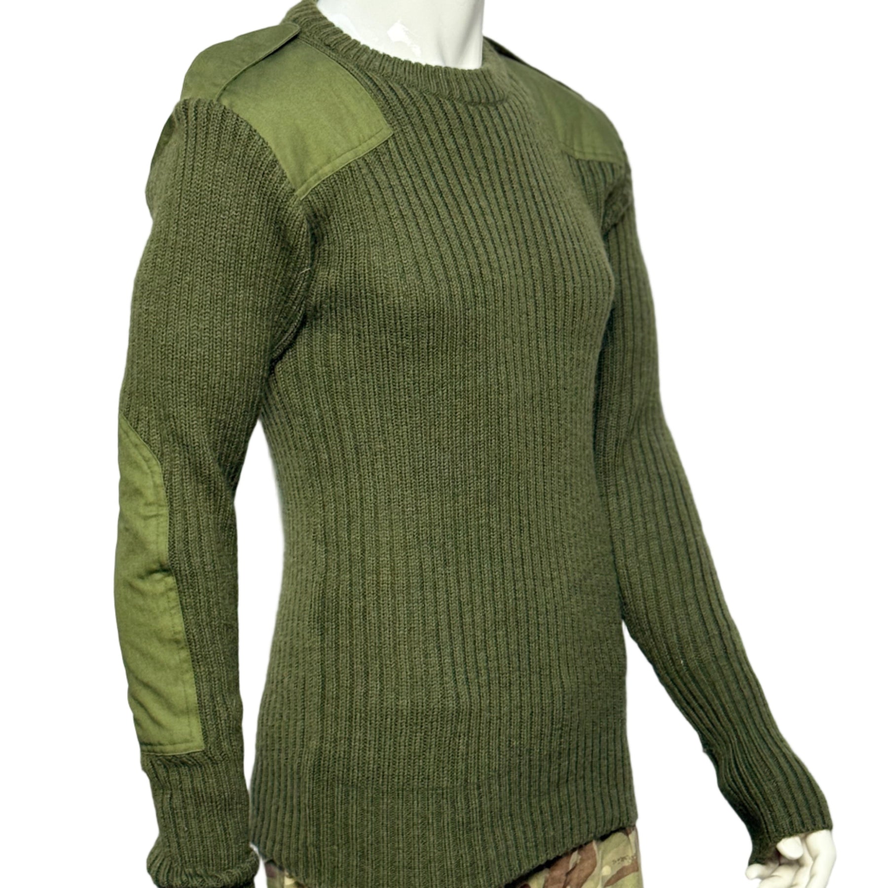 Green ribbed wool jumper on a mannequin with camouflage pants underneath against a white background