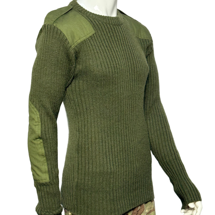 Green ribbed wool jumper on a mannequin with camouflage pants underneath against a white background